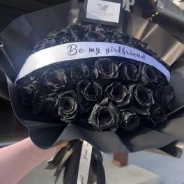 Black rose bouquet wrapped in black paper with a "Be my girlfriend" ribbon