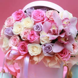 Pink and white roses with orchids in a round hatbox