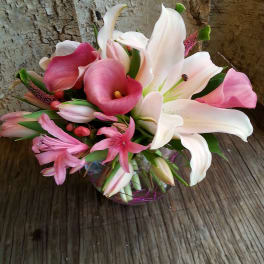 Pink and white calla lilies and lilies arranged in a low bouquet
