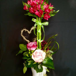 Pink and white roses in a white pot with a tall pink flower cluster