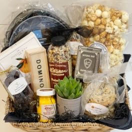 Gift basket with popcorn, cookies, chocolates, cards, and a small potted succulent