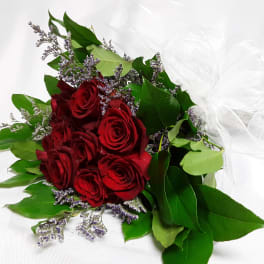 Bouquet of red roses with purple filler and a white ribbon bow