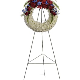 Standing funeral wreath with red and white flowers on an easel