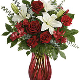 Red roses and white lilies in a red glass vase