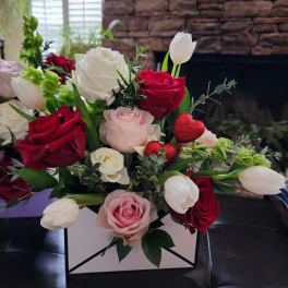 Bouquet of red, pink, and white roses with white tulips in a box