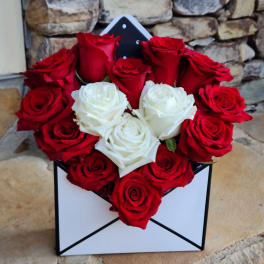 Red and white roses arranged in a black-and-white box