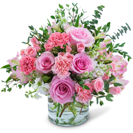 Pink roses and carnations in a clear glass vase