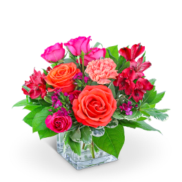 Pink and orange roses with red alstroemeria in a glass vase