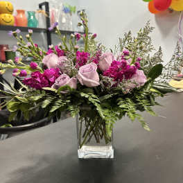 Pink and lavender roses in a clear glass vase