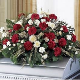Red and white carnation spray on a casket