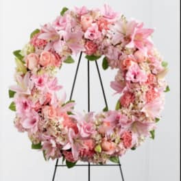 Pink floral wreath on a black stand