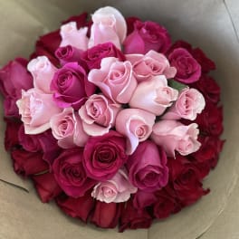 Bouquet of pink and red roses wrapped in brown paper