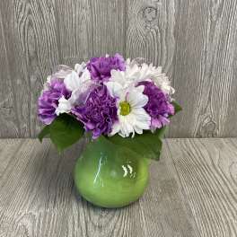 Purple and white flowers arranged in a green vase