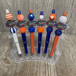 Six decorated pens with Florida Gators logos in a clear holder