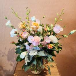 Pastel rose and lisianthus arrangement in a glass vase