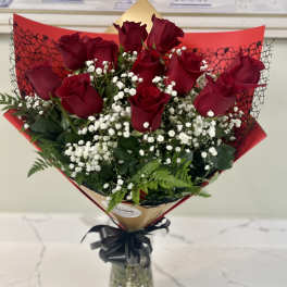 Bouquet of red roses and white baby's breath in a glass vase