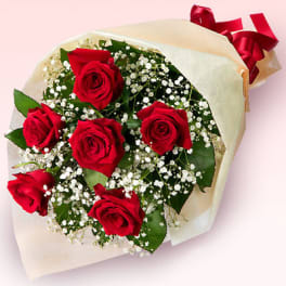 Bouquet of red roses with baby's breath wrapped in cream paper