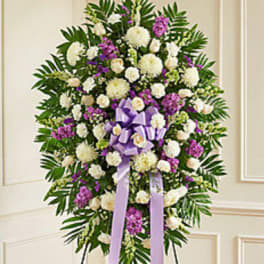 Standing floral spray with white and purple flowers and a lavender ribbon