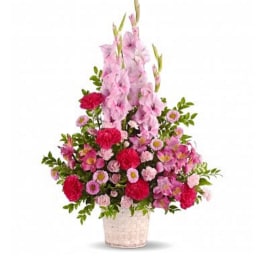 Tall pink floral arrangement in a woven basket