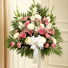 Standing floral spray with pink and white flowers and a white ribbon