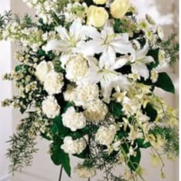 White lilies and pale yellow roses in a standing floral spray