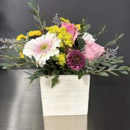 Mixed bouquet in a white rectangular vase with pink and yellow flowers