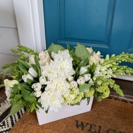 White floral arrangement in a rectangular white container