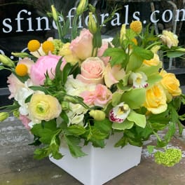 Pastel floral arrangement in a white square vase