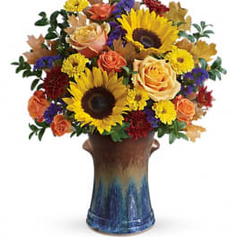 Bouquet of sunflowers, roses, and mums in a ceramic vase