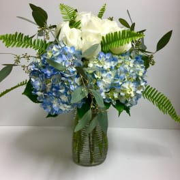 Blue hydrangeas and white roses in a glass vase