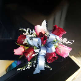 Small bouquet of red and pink roses tied with a blue ribbon
