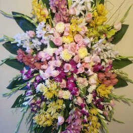 Large cascading bouquet of orchids, roses, and mums in pink, yellow, white, and purple