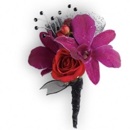Red rose boutonniere with purple orchid petals and black accents