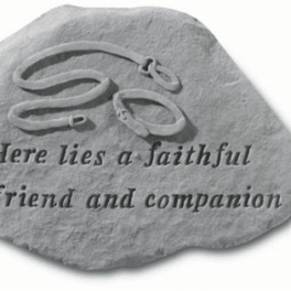 Gray memorial stone with engraved text and a carved dog collar