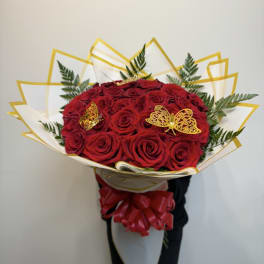 Bouquet of red roses with gold butterfly accents and white-gold wrapping