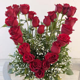 Heart-shaped arrangement of red roses with baby's breath