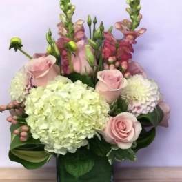 Pink roses and hydrangeas in a square glass vase
