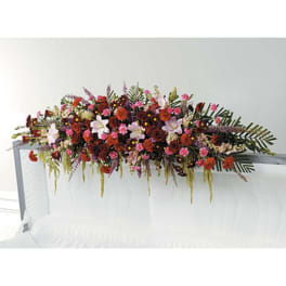 Long floral casket spray with pink, red, and white blooms