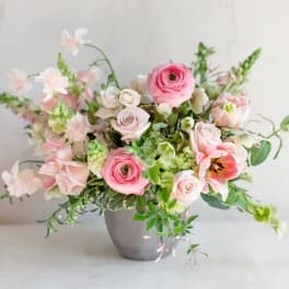 Pink and white floral arrangement in a gray vase