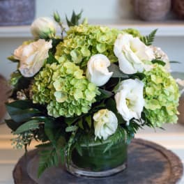 White roses and green hydrangeas in a glass vase