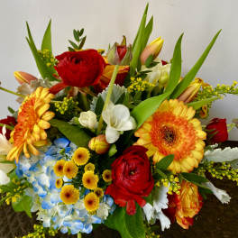 Mixed bouquet with red roses, orange gerbera daisies, and blue hydrangea