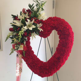 Heart-shaped red floral wreath with white lilies and red roses