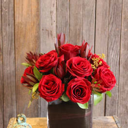 Red roses arranged in a square glass vase