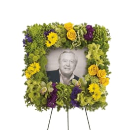 Square floral funeral frame around a portrait on an easel