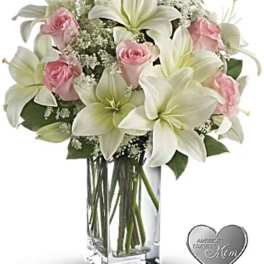 Pink roses and white lilies in a clear glass vase