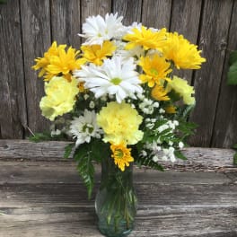 Yellow and white daisy bouquet in a glass vase