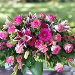 Pink roses and lilies arranged in a low vase centerpiece
