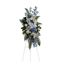 Tall white and blue floral standing spray on a white easel