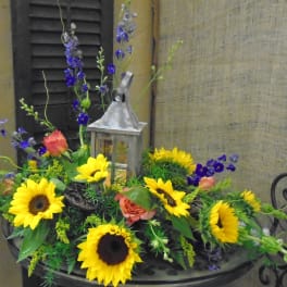 Sunflower arrangement with roses and a lantern centerpiece