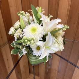 White lilies and chrysanthemums in a green striped vase